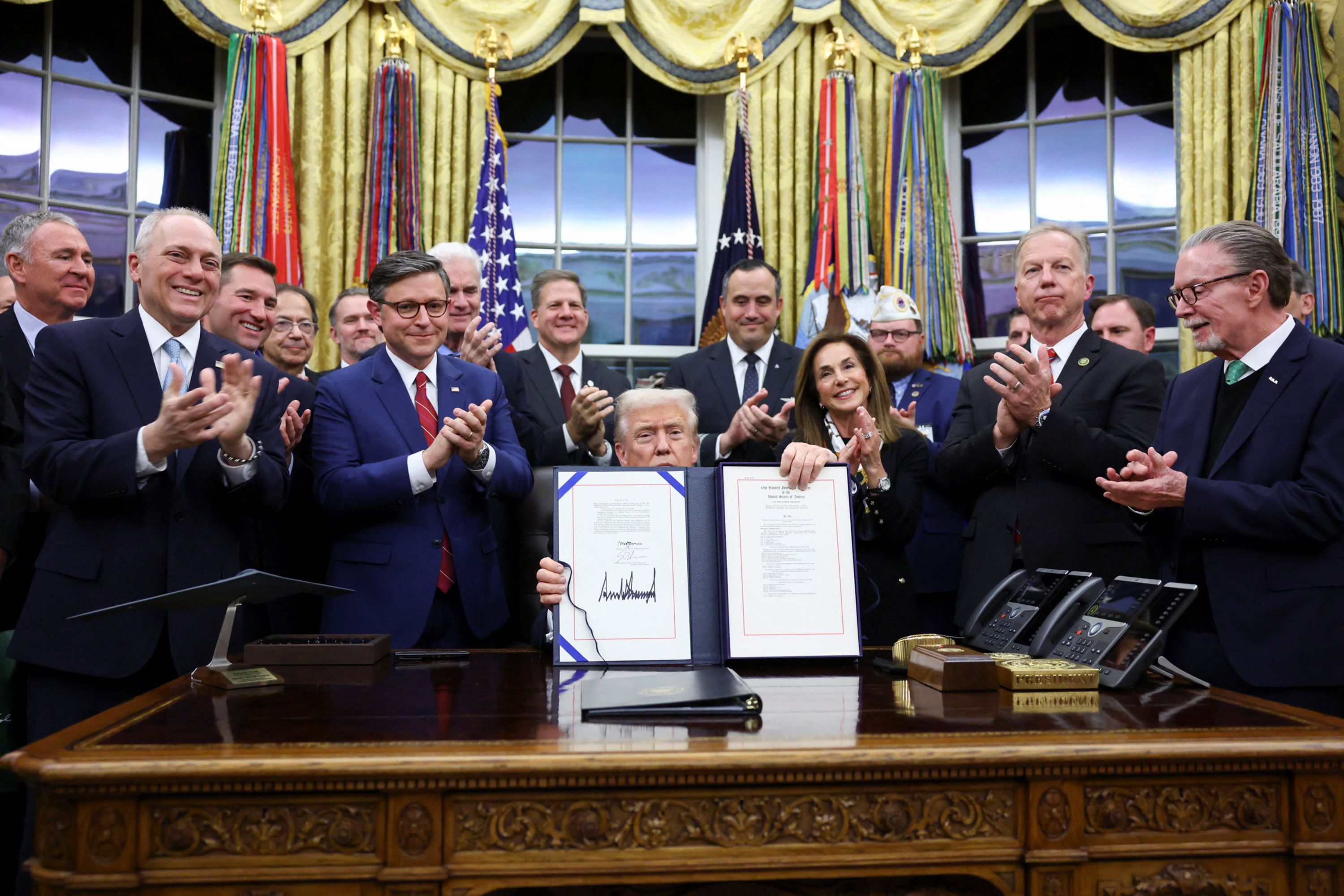 President Donald Trump poses with lawmakers in the White House Oval Office after signing a funding bill to end the government shutdown on Wednesday, November 12.