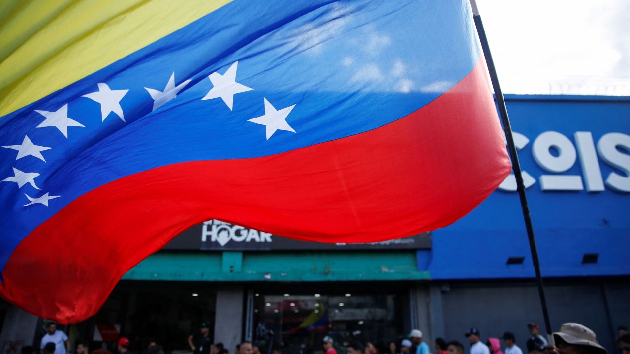 A person holds a Venezuelan flag during a march with young members of the United Socialist Party of Venezuela (PSUV) in Caracas, Venezuela, November 13, 2025.