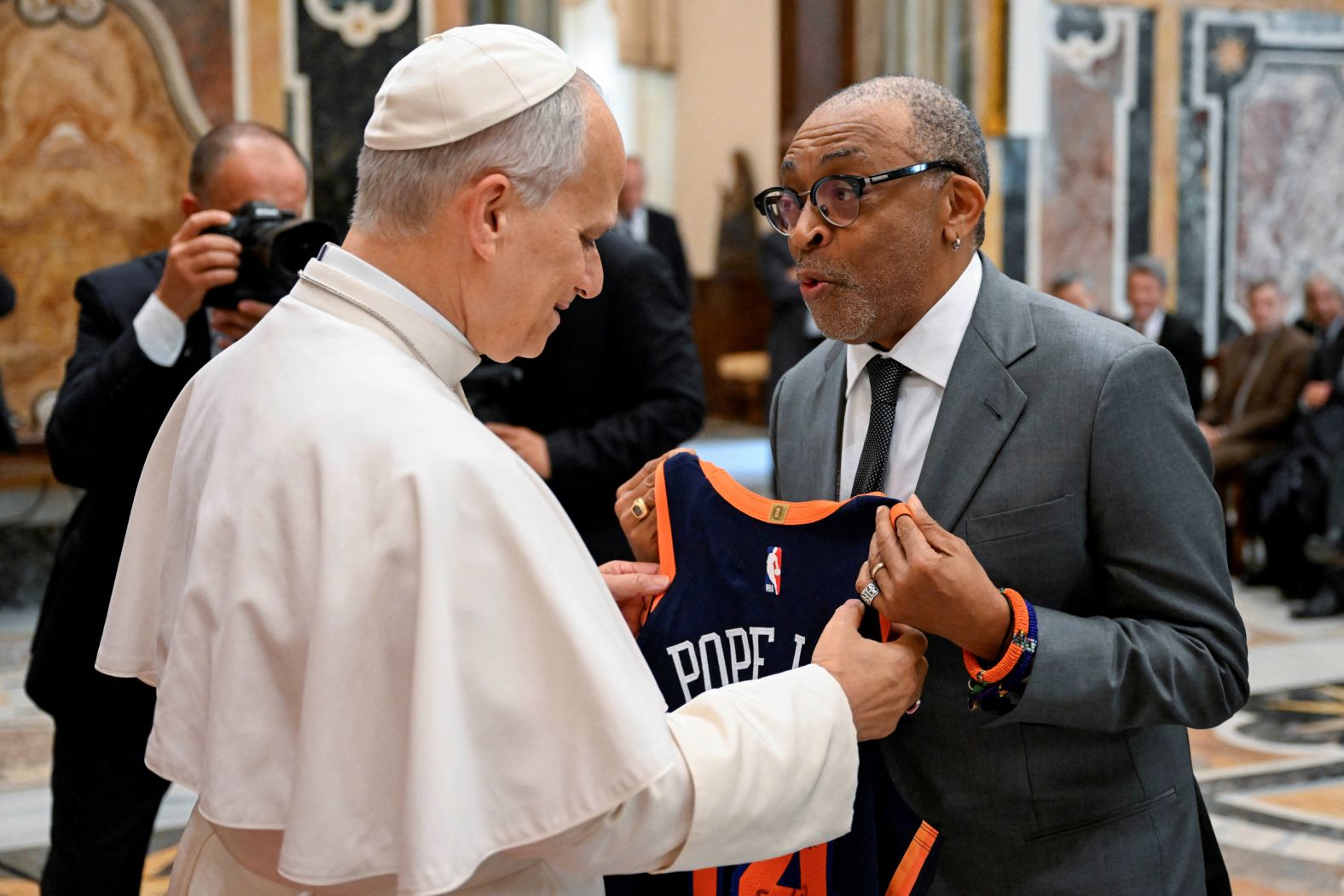 Pope Leo XIV receives a New York Knicks basketball jersey from filmmaker Spike Lee at the Vatican on Saturday, November 15. The pope, <a href="index.php?page=&url=https%3A%2F%2Fwww.cnn.com%2F2025%2F11%2F15%2Feurope%2Fleo-hollywood-vatican-cinema-intl">while meeting with Hollywood film stars and directors</a>, called cinema a “workshop of hope.” Lee is a passionate fan of the Knicks, and the Knicks have several star players who, like the pope, attended Villanova University.