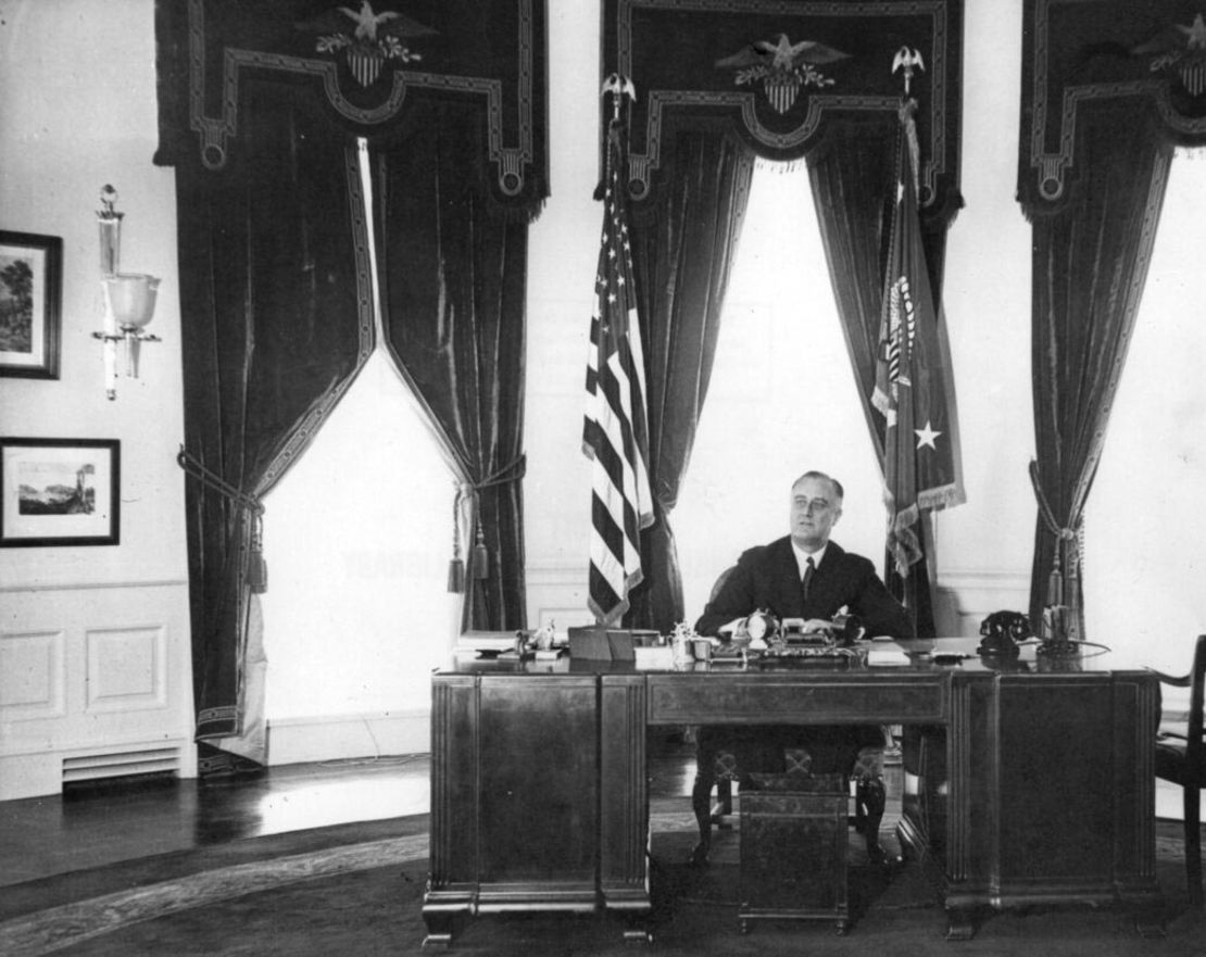 O Presidente Franklin D. Roosevelt está sentado na mesa Hoover, no Salão Oval em 1935.