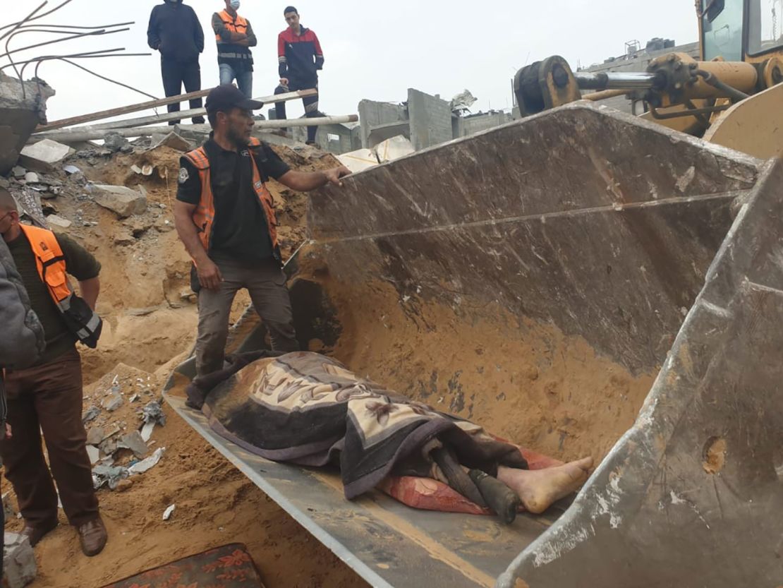 Palestinian Civil Defense at the site of the attack on the al-Jazzar family home where a giant crater was seen in the aftermath. Journalists in the area told CNN that 18 people were killed.