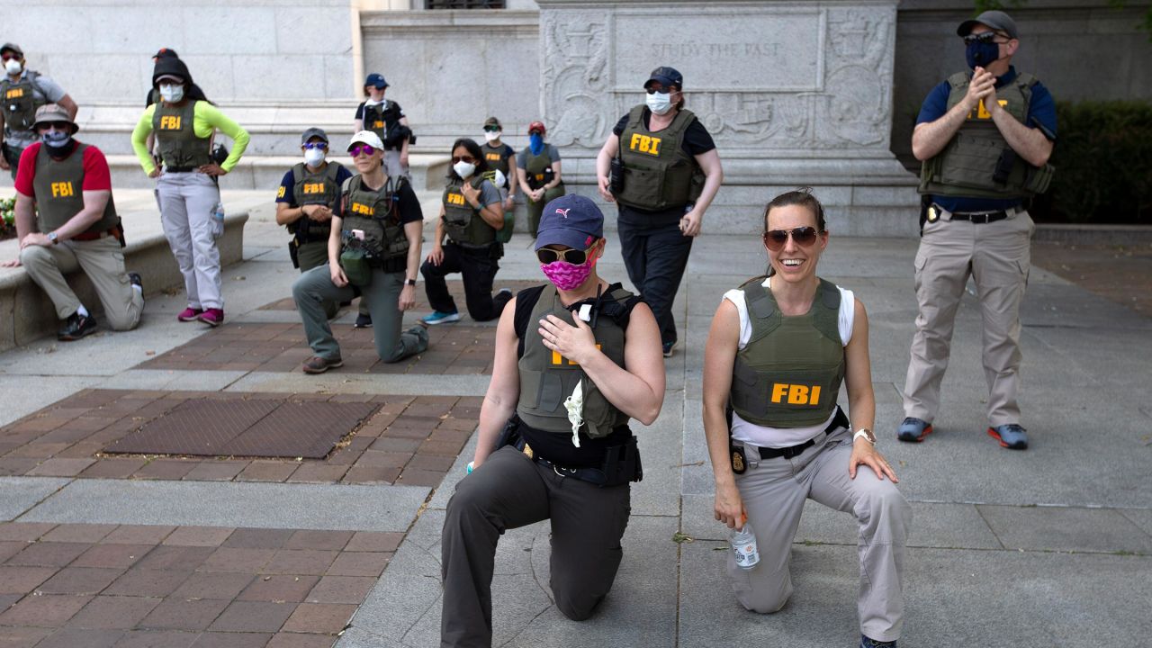 Federal Bureau of Investigation officers take a knee with demonstrators on Pennsylvania Avenue on June 4, 2020, in Washington, DC. 