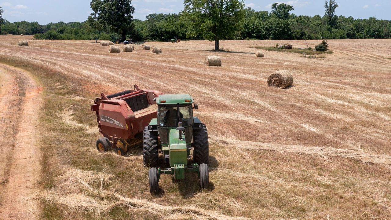 In this May 2021 phto, farmer John Boyd Jr. runs his hay bailer at his farm in Boydton, Virginia.