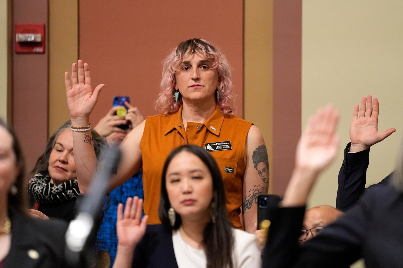 Leigh Finke, center, the first transgender person elected to the state's legislature, is sworn in to the Minnesota House of Representatives during the first day of the 2023 legislative session in January 2023 in St. Paul, Minnesota. 