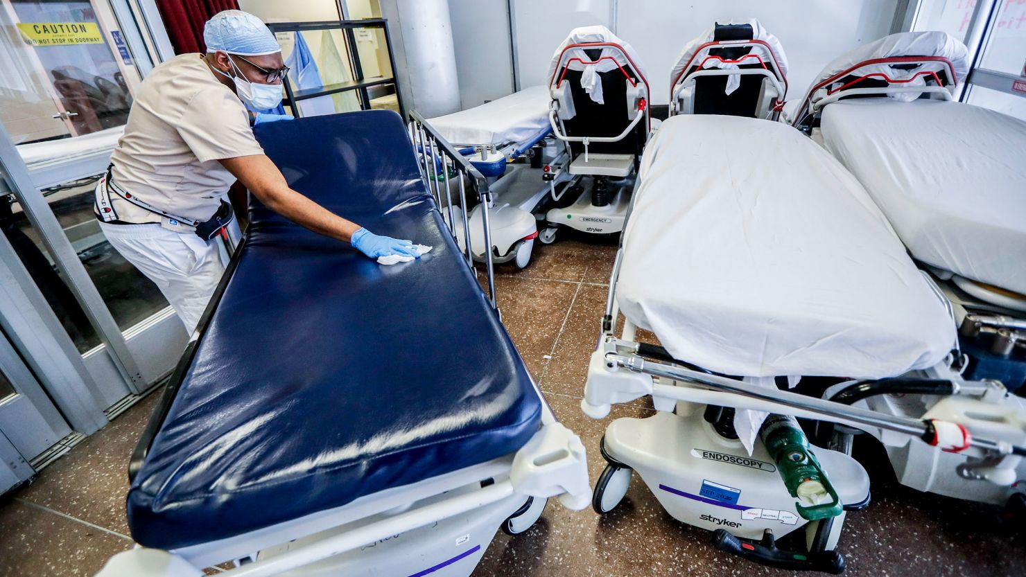 In this May 2020 photo, a medical worker cleans gurneys in the emergency department intake area at a hospital in New York. 