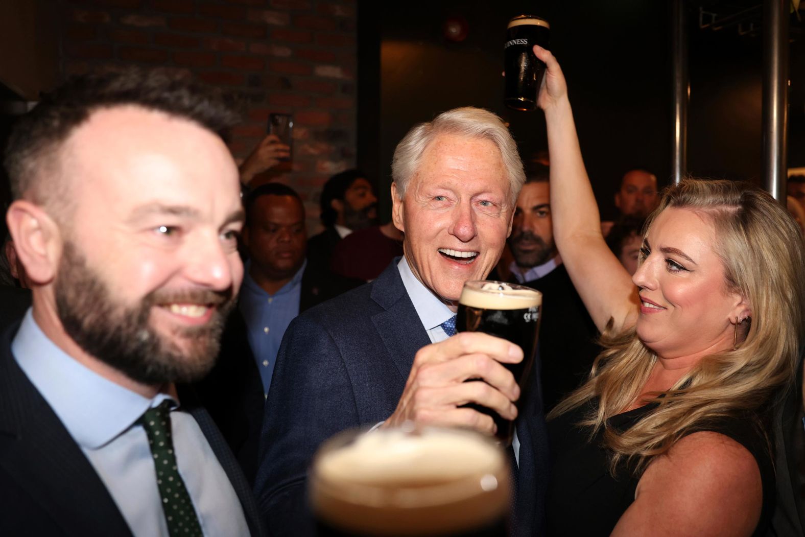 Clinton, center, and Colum Eastwood, then-leader of Northern Ireland’s Social Democratic and Labour Party, left, enjoy pints of Guinness in Londonderry, Northern Ireland, during the 25th anniversary of the Good Friday Agreement in April 2023. Clinton’s 1995 visit and peace talks were pivotal in ending the Northern Ireland conflict.