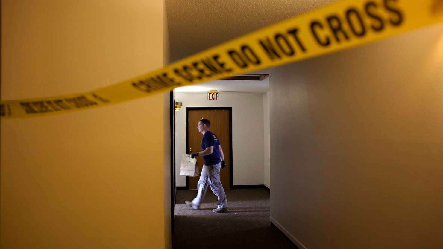 An FBI Evidence Response Team investigator walks behind a crime scene in July 2023 in Fargo, North Dakota. 