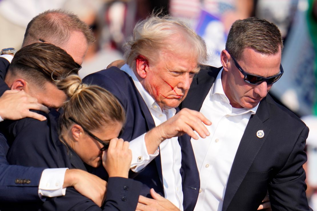 Sean Curran, the top-ranking agent on Trump’s detail, right, helps direct Trump off stage with other US Secret Service agents at a campaign event in Butler, Pennsylvania, on July 13.