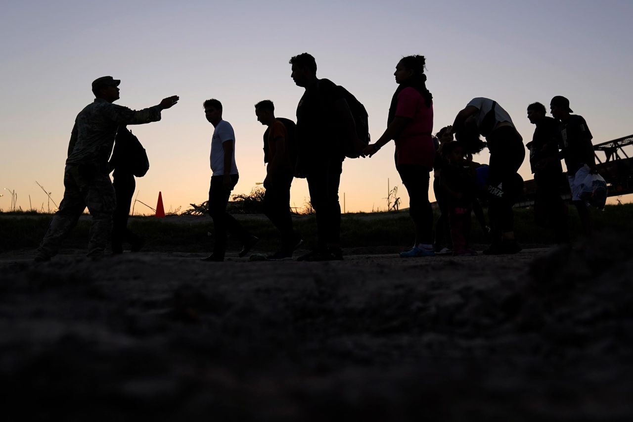 In this September 2023 photo, migrants who crossed the Rio Grande and entered the US from Mexico are lined up for processing by US Customs and Border Protection in Eagle Pass, Texas. 