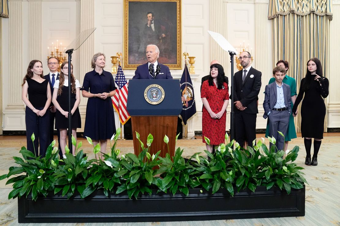 President Joe Biden speak to members of press surrounded by family members of the released prisoners.