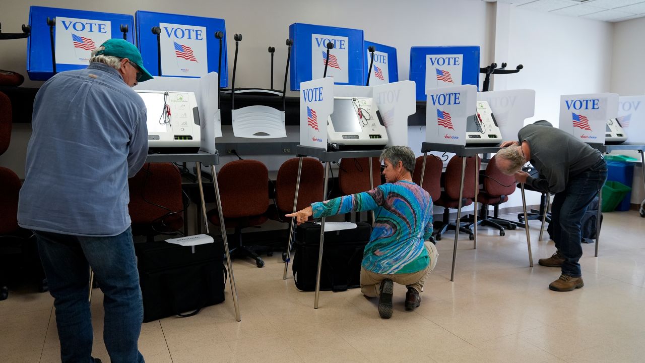 Poll workers set up ballot-marking machines at an early in-person voting site at Asheville-Buncombe Technical Community College on October 16, 2024. 