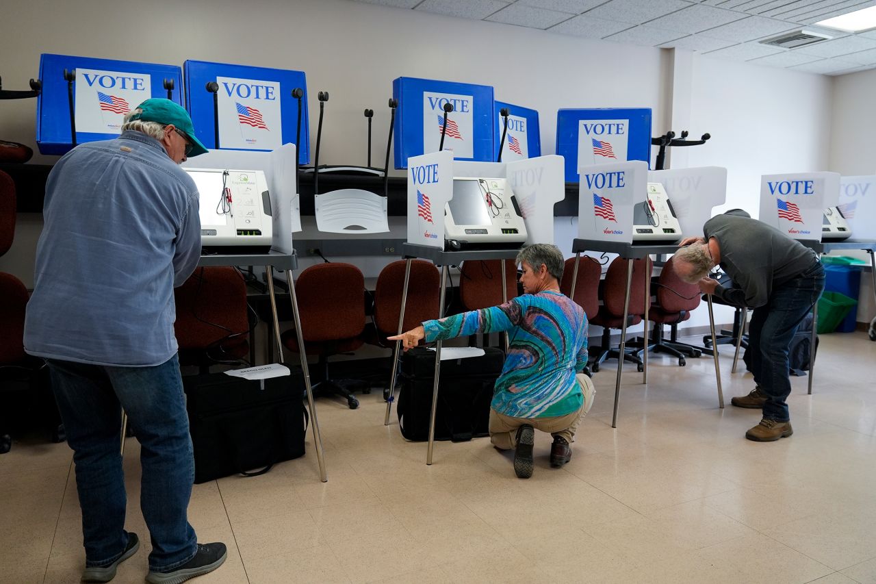 Poll workers set up ballot-marking machines at an early in-person voting site at Asheville-Buncombe Technical Community College on October 16, 2024. 