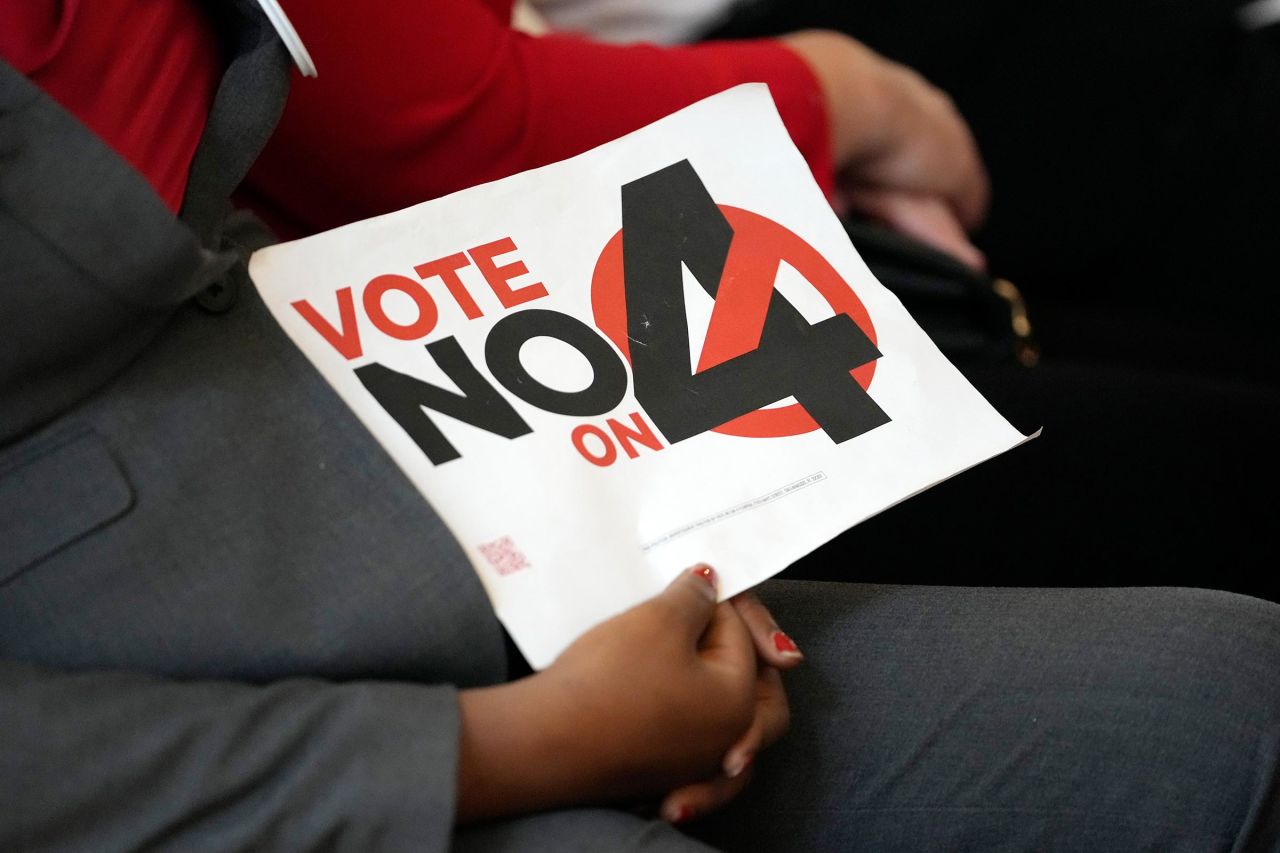 A person holds a sign against Amendment 4 during a news conference in Coral Gables, Florida, on October 21.