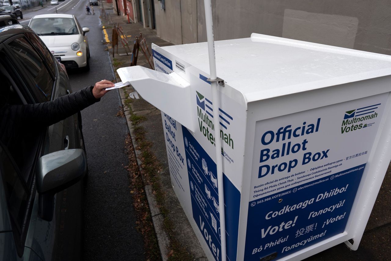 A person drops off their 2024 election ballot at a newly installed drop box outside the Multnomah County Elections Division office on October 28 in Portland.