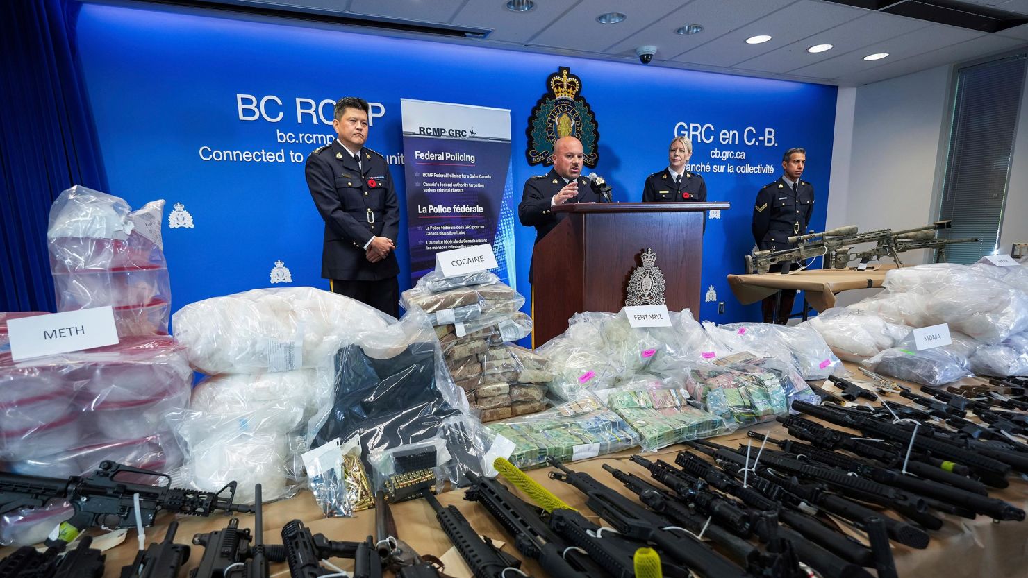 This October 2024 photo shows seized firearms and illicit drugs, including fentanyl, on display at a Royal Canadian Mounted Police news conference in Surrey, British Columbia.