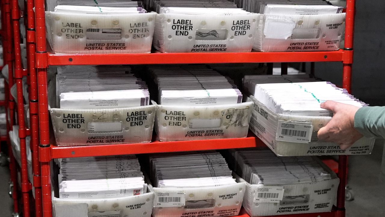 In this April 18 photo, Allegheny County Election Division Deputy Manager Chet Harhut carries a container of mail-in ballots from a secure area at the elections warehouse in Pittsburgh.