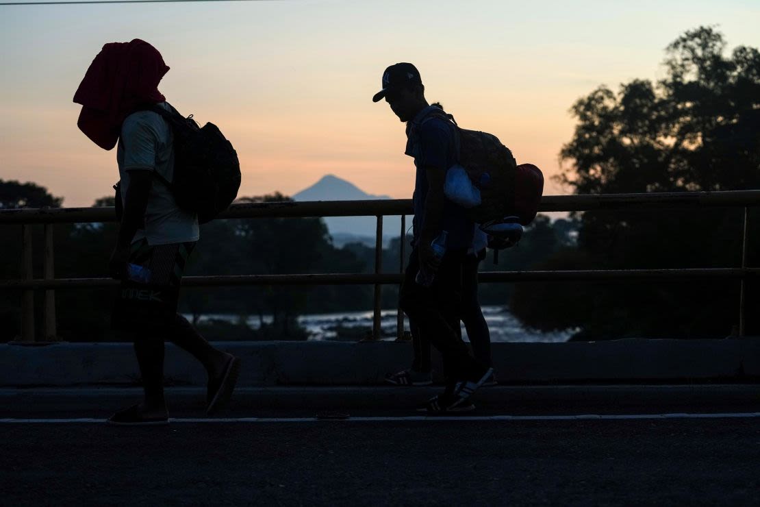 Con el volcán Tajumulco al fondo, migrantes caminan por la carretera de Huixtla, en el sur de México, el 6 de noviembre, con la esperanza de llegar a la frontera norte del país y, en última instancia, a Estados Unidos.