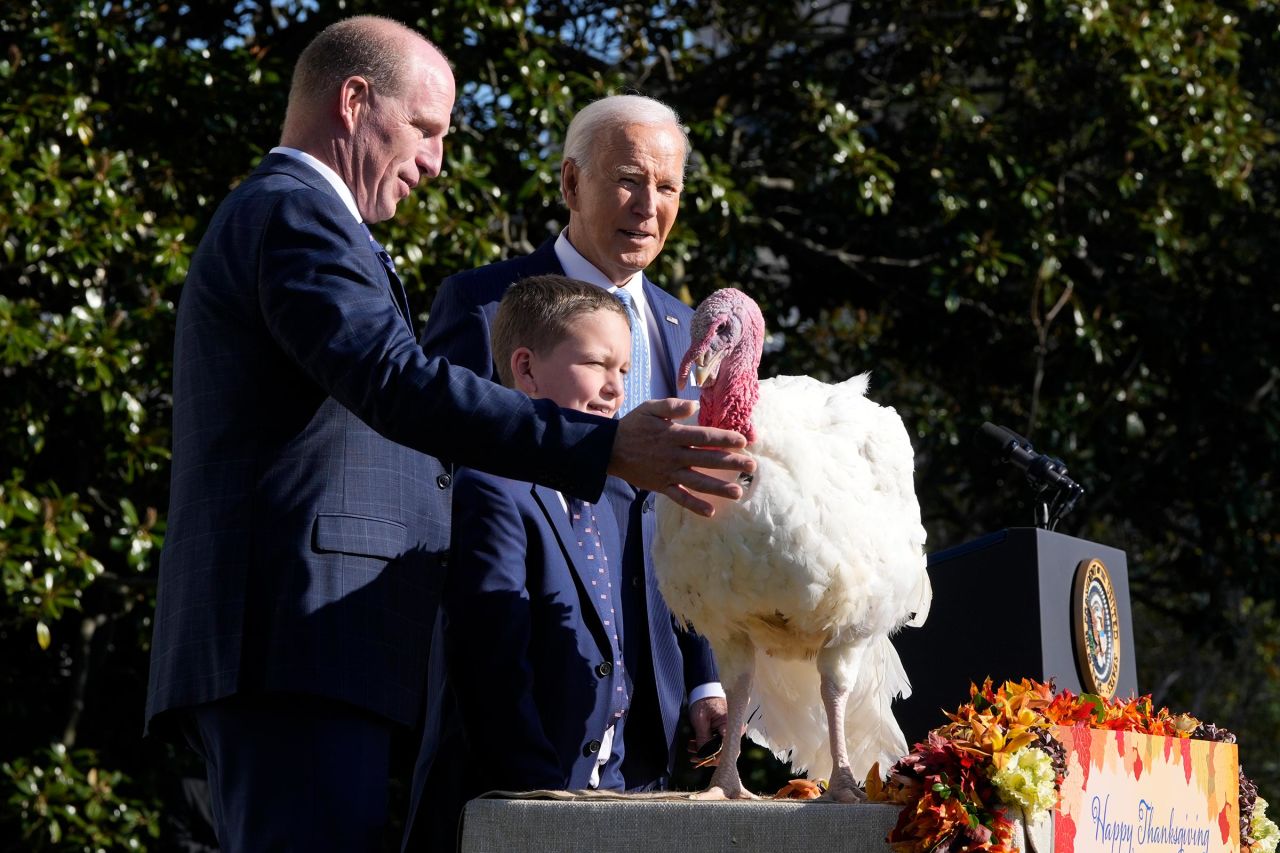 President Joe Biden is pictured with John Zimmerman, chair of the National Turkey Federation, from left, and Zimmerman's son Grant, after pardoning the national Thanksgiving turkey Peach during a ceremony on the South Lawn of the White House in Washington, DC, on Monday, November 25. 