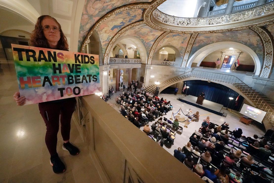 In this March 2023 photo, Julia Williams holds a sign in counterprotest during a rally in favor of a ban on gender-affirming health care legislation at the Missouri Statehouse in Jefferson City, Missouri.