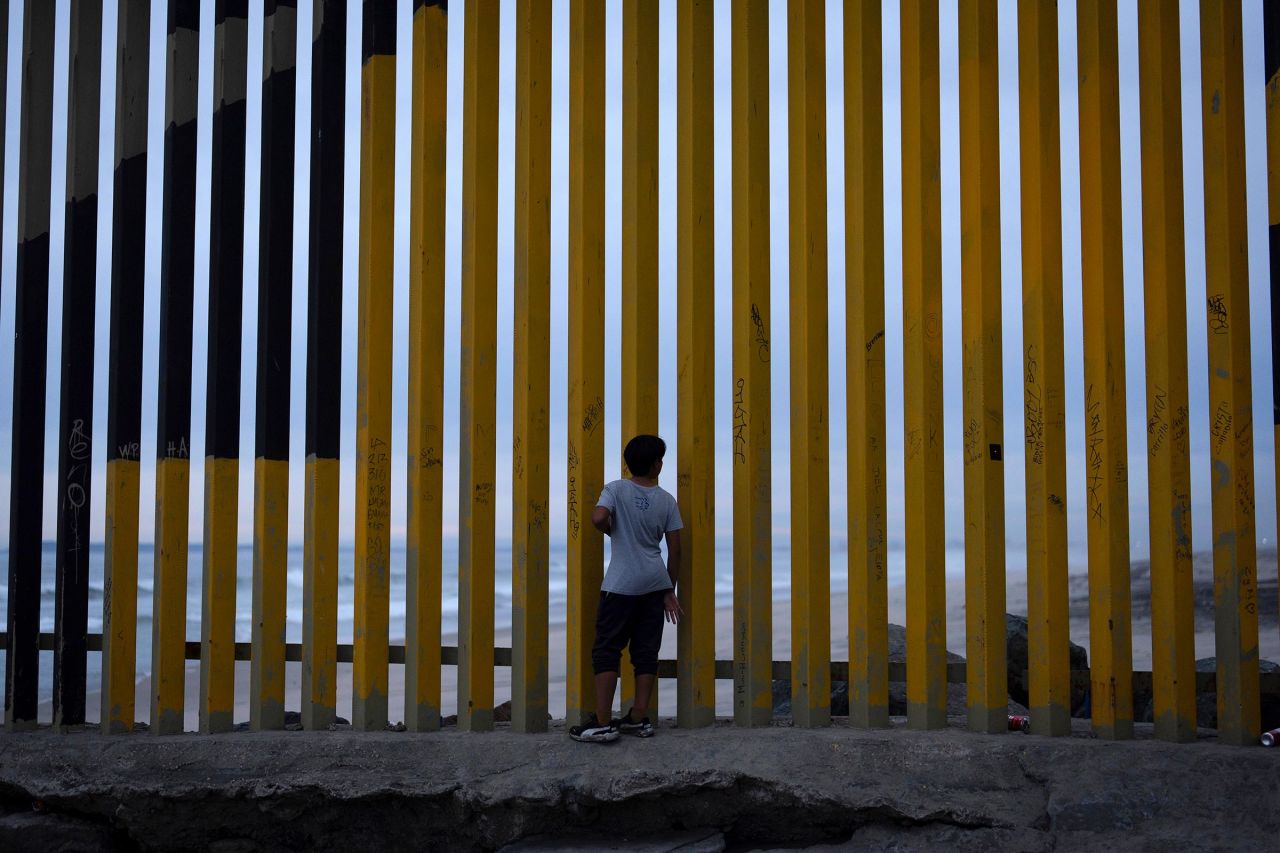 A boy looks through a border wall separating Mexico from the United States in November in Tijuana. 