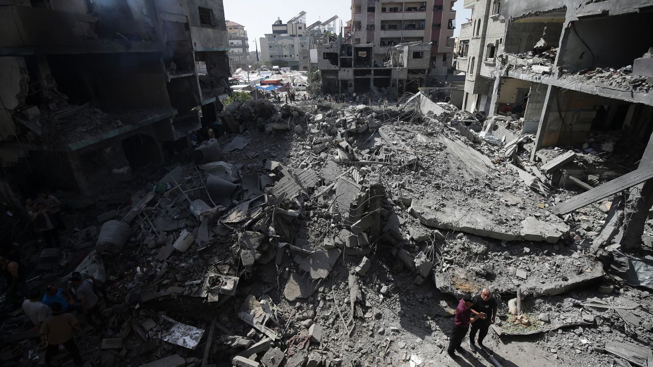 Palestinians look at the aftermath of an Israeli bombing in Nuseirat refugee camp in the Gaza Strip in June. 