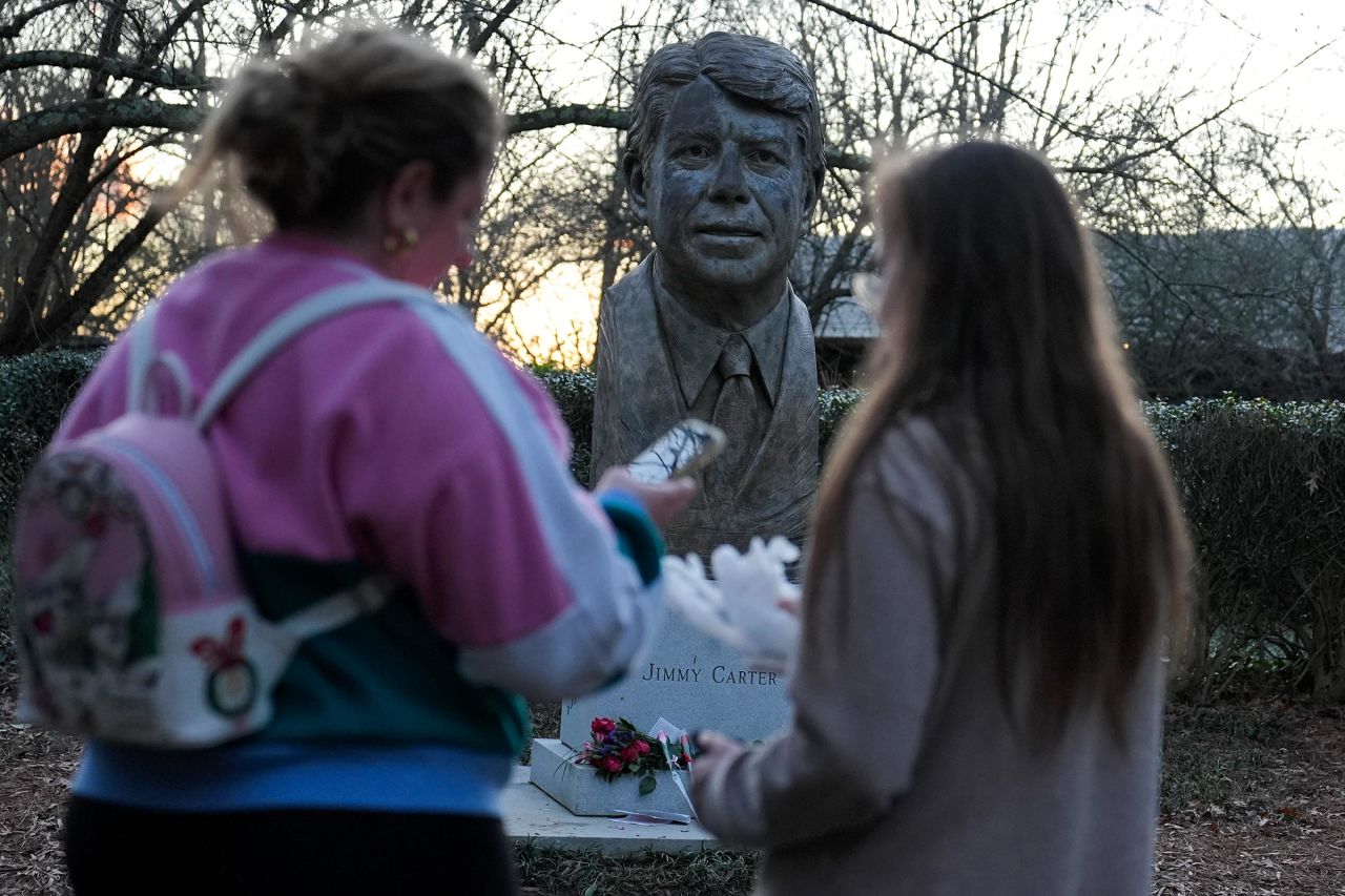 People visit a bust of Carter at the Jimmy Carter Presidential Library and Museum on Sunday in Atlanta.