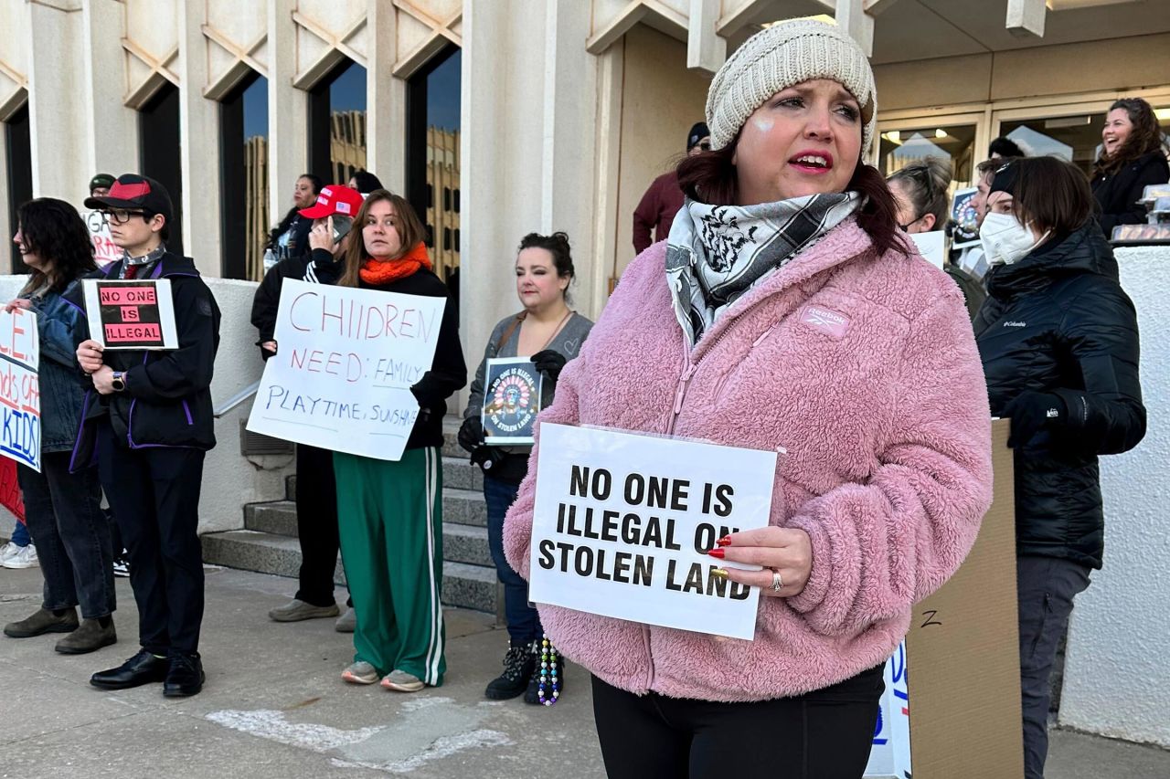 Erica Watkins of Tulsa, the state director of Defense of Democracy, holds a sign to protest Oklahoma's Board of Education considering a rule that would require parents enrolling children in public schools to provide proof of their child's US citizenship or legal immigration status on Tuesday in Oklahoma City.