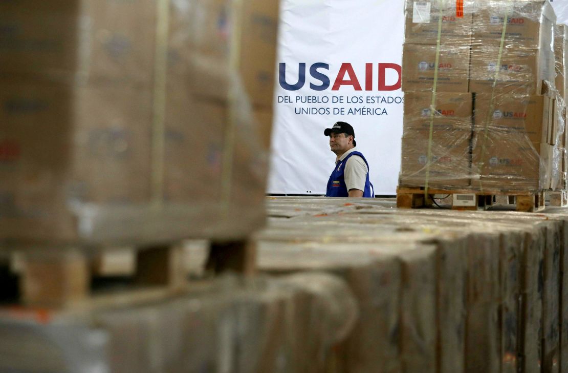 Um homem passa por caixas de ajuda humanitária da USAID em um armazém na ponte internacional de Tienditas nos arredores de Cucuta, na Colômbia, em 2019. 