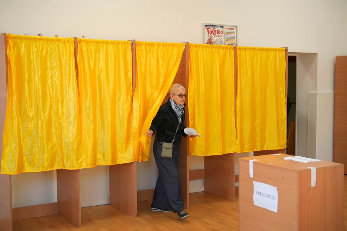 A woman exits a voting booth before casting her vote in the first round of the presidential election redo in Bucharest, Romania, on May 4.