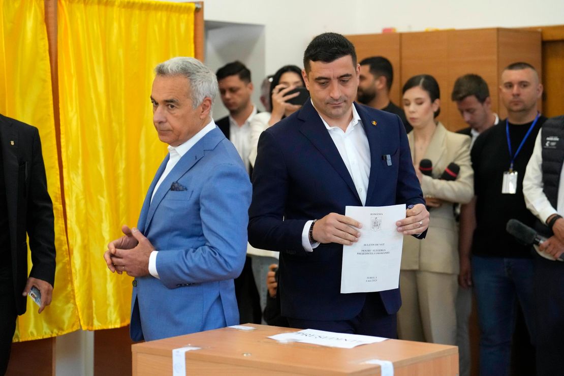 Presidential candidate George Simion, right, casts his vote next to Calin Georgescu, winner of the first round of last year's annulled election, during the first round of the presidential election redo in Bucharest, Romania, on May 4. 