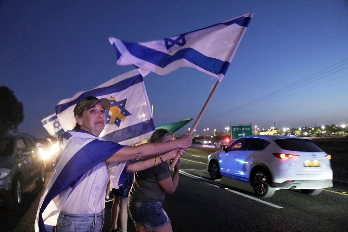 Israelis wave flags near an army base in Re'im in southern Israel on May 12.