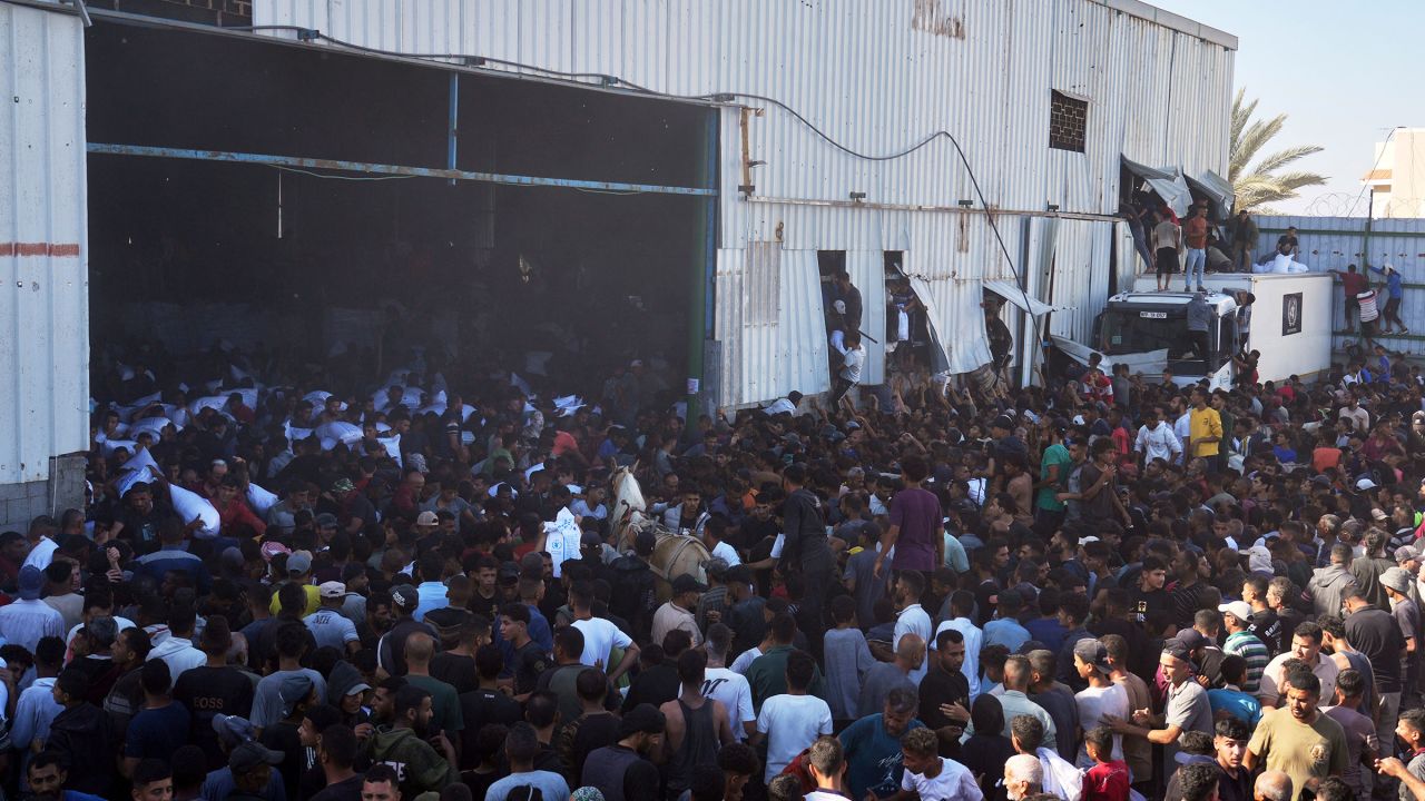 Palestinians storm a UN World Food Program warehouse and carry bags of flour in Zawaida, Central Gaza Strip, on May 28, 2025.
