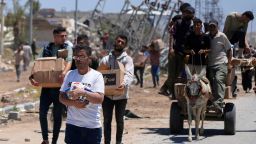 Palestinians carry boxes and bags containing food and humanitarian aid packages delivered by the Gaza Humanitarian Foundation, a US-backed organization approved by Israel, in Khan Younis on May 29.