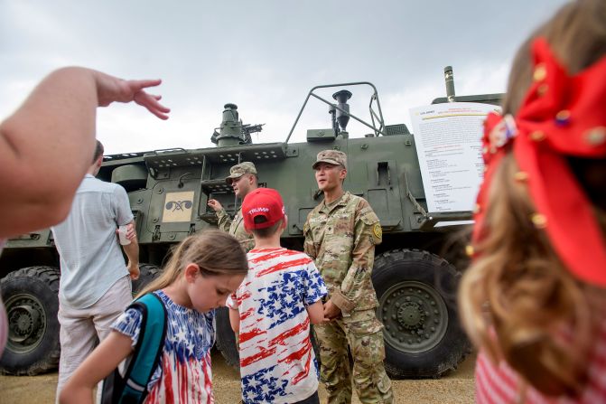 People stop to look at an Army M1135 NBC Reconnaissance Vehicle parked on the National Mall.