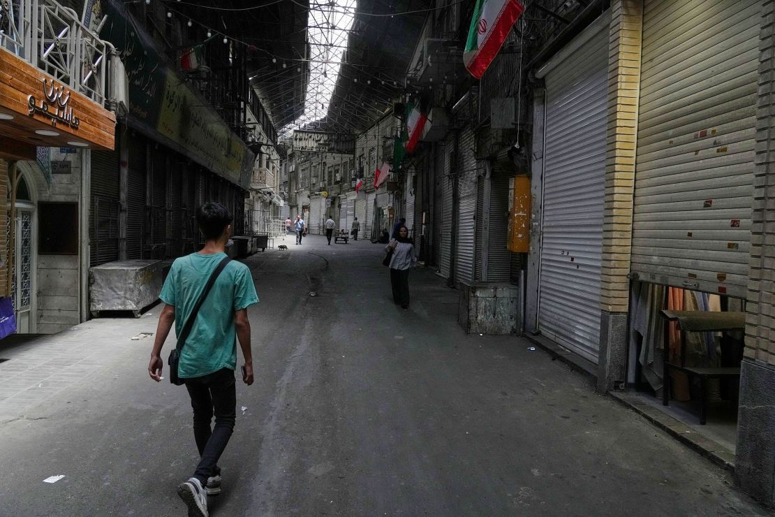 Few pedestrians walk along the historic Grand Bazaar as shops remain shuttered, in Tehran, Iran, on Monday.