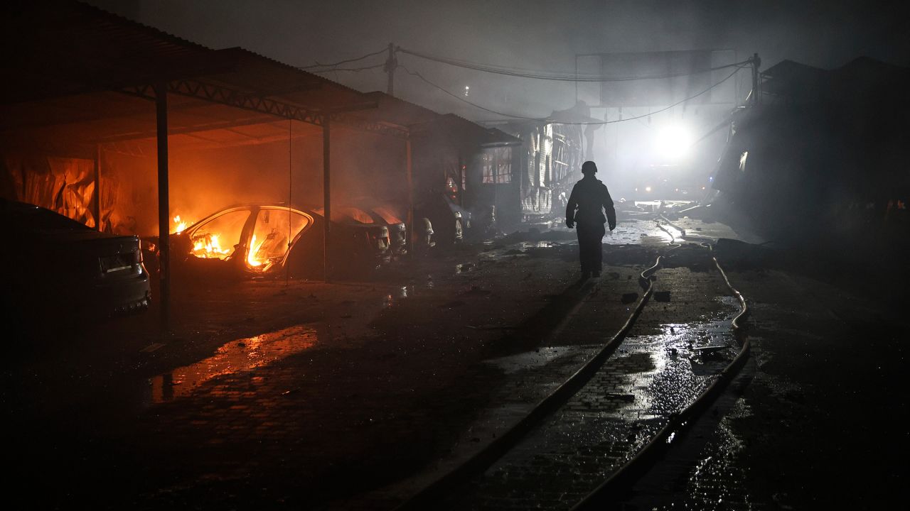 A rescue worker walks on a parking of car repair service destroyed by a Russian drone strike in Zaporizhzhia, Ukraine, on June 18.