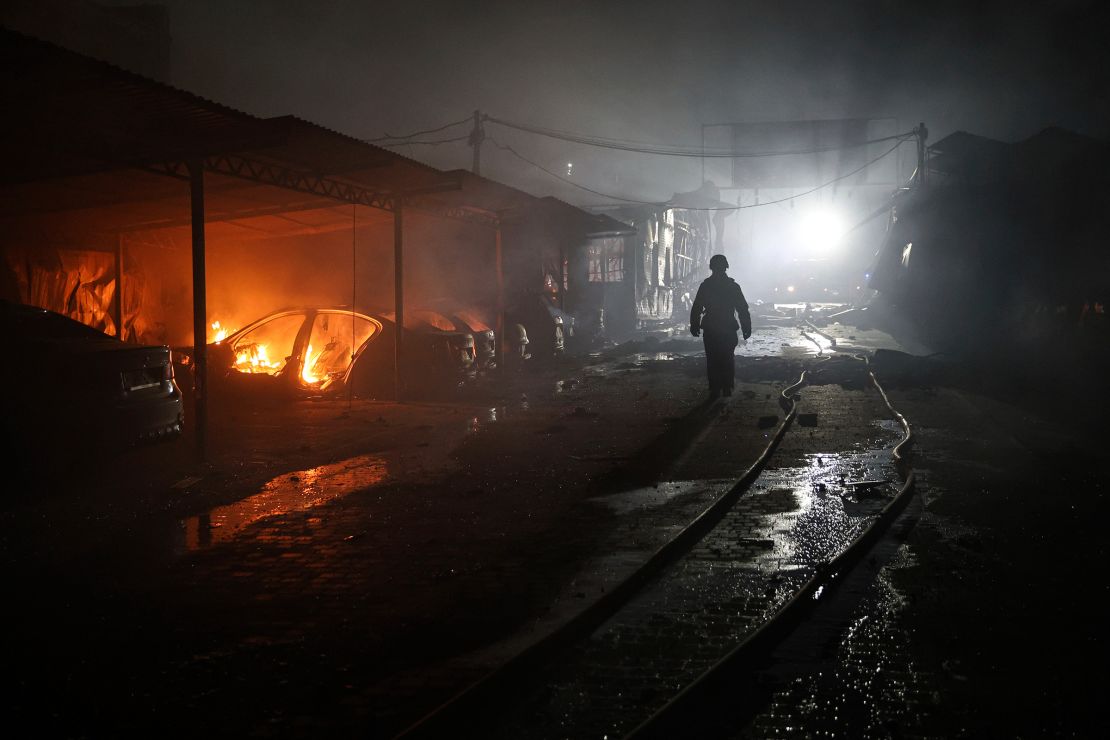 A rescue worker walks on a parking of car repair service destroyed by a Russian drone strike in Zaporizhzhia, Ukraine, on June 18.