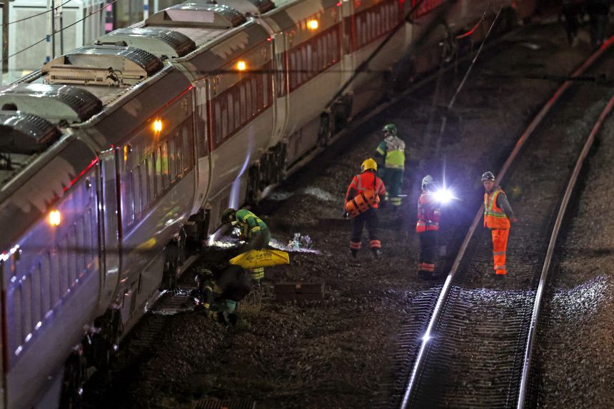 A rescue worker stands next to a train at Huntingdon station in Cambridgeshire after several people were stabbed. Two people were arrested after British Transport Police were called to the scene of an incident on a train on Saturday 1 November 2025.
