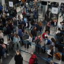 Travelers wait at a security checkpoint at O'Hare International Airport in Chicago, Friday, Nov. 7, 2025.