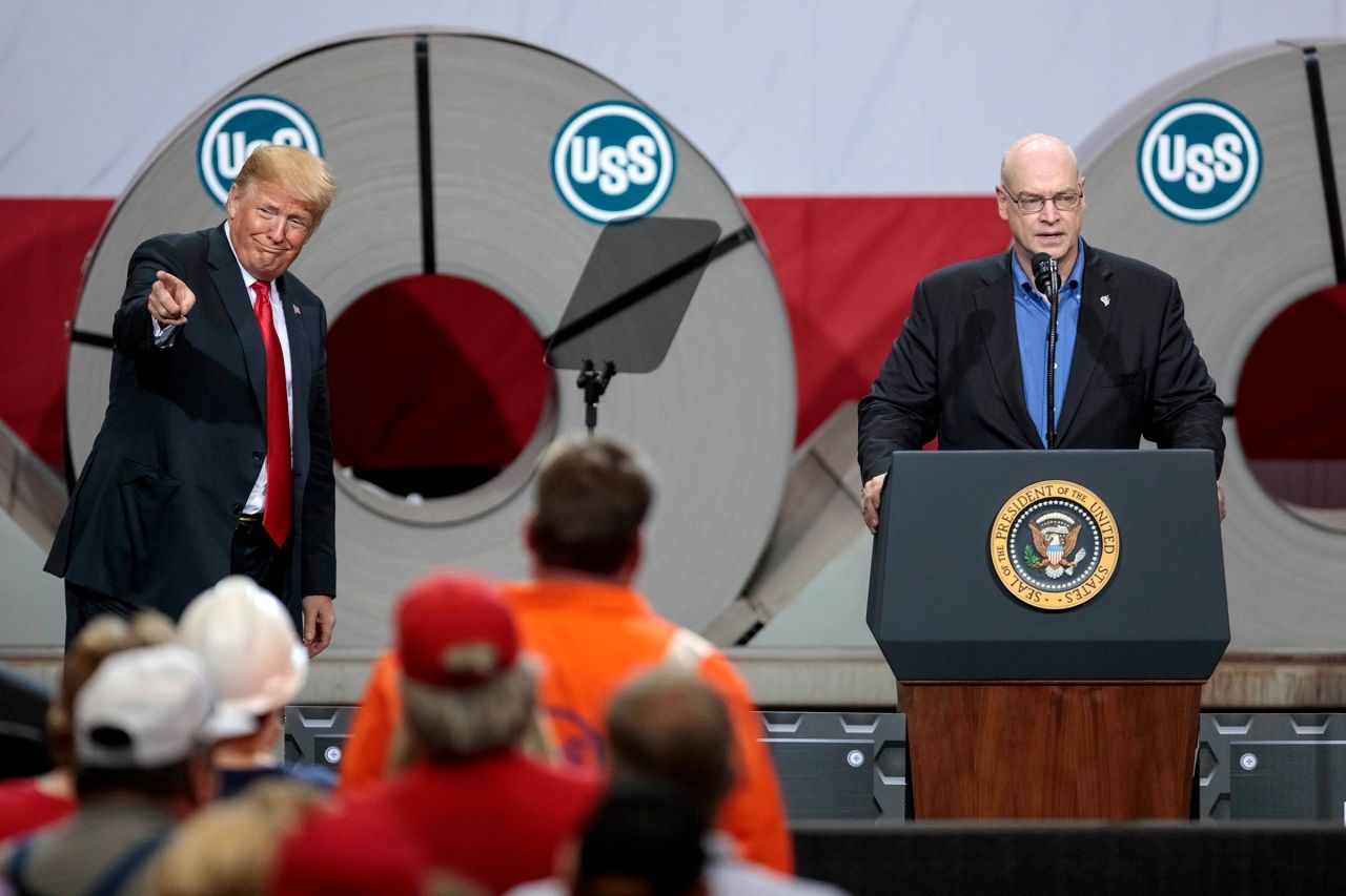 In this 2018 photo, Donald Trump motions to the crowd as David B. Burritt, President & Chief Executive Officer of U.S. Steel, speaks at U.S. Steel's Granite City Works plant in Granite City, Illinois. 