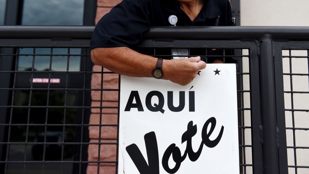 In this October 2018 photo, A Bexar County employee sets up signs during early voting at a polling location in San Antonio, Texas. 