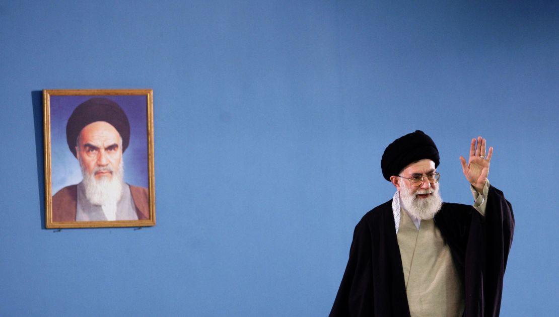 In this 2006 photo, Iran's supreme leader Ayatollah Ali Khamenei waves next to a portrait of Iran's late founder of Islamic republic Ayatollah Khomeini during a meeting in Tehran.