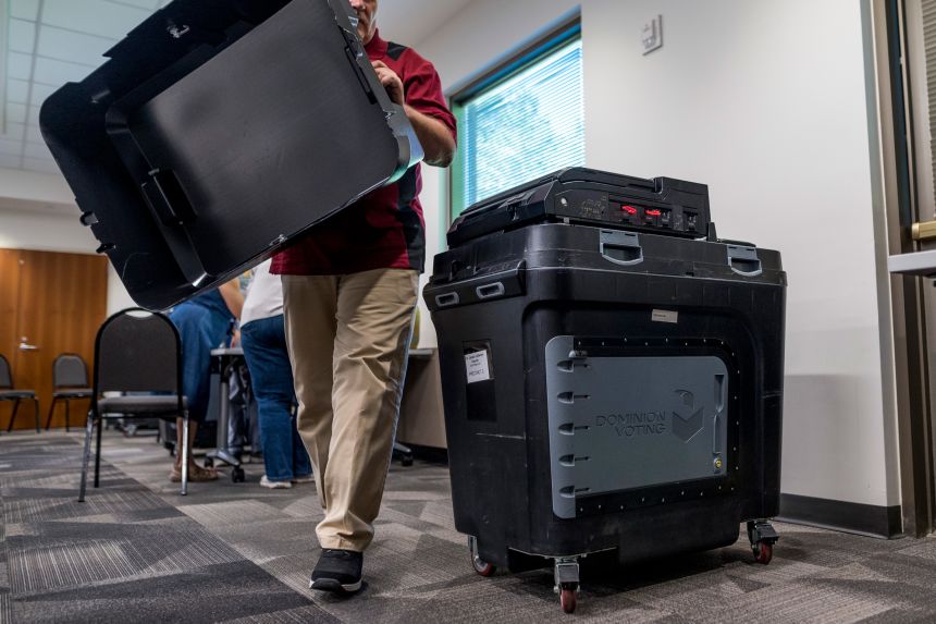 An election judge sets up a Dominion voting machine during a public accuracy test of voting equipment on August 3, 2022, in Burnsville, Minnesota.