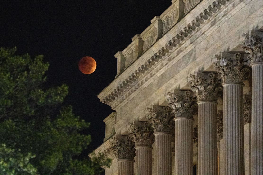 A Beaver Blood Moon Lunar Eclipse is seen setting behind the US Capitol Building on November 8, 2022, in Washington, DC.