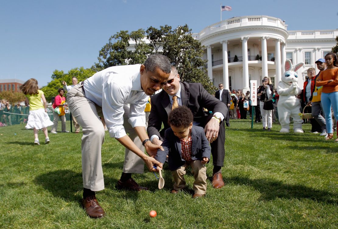 President Barack Obama helps a young participant roll an egg during the White House Easter Egg Roll on the South Lawn of the White House in April 2012.