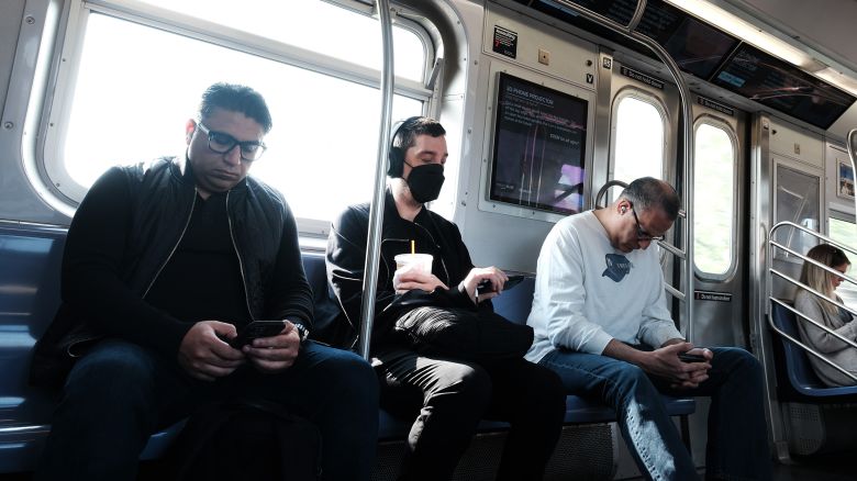 People, some still wearing face masks, ride a subway in Brooklyn in May 2023 in New York City.