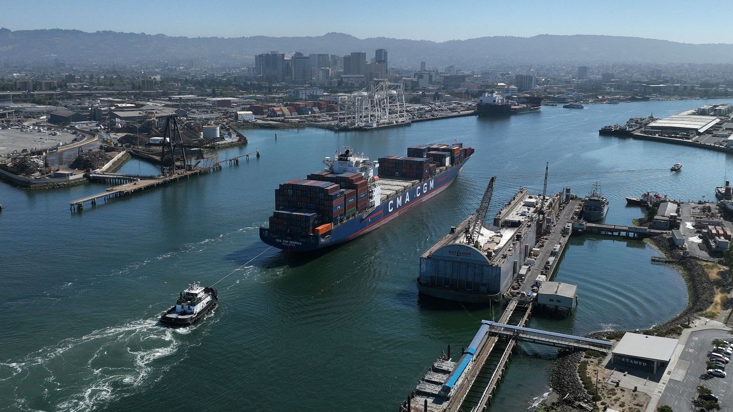 In an aerial view, a container ship is guided into the Port of Oakland on August 7, 2023 in Oakland, California. 