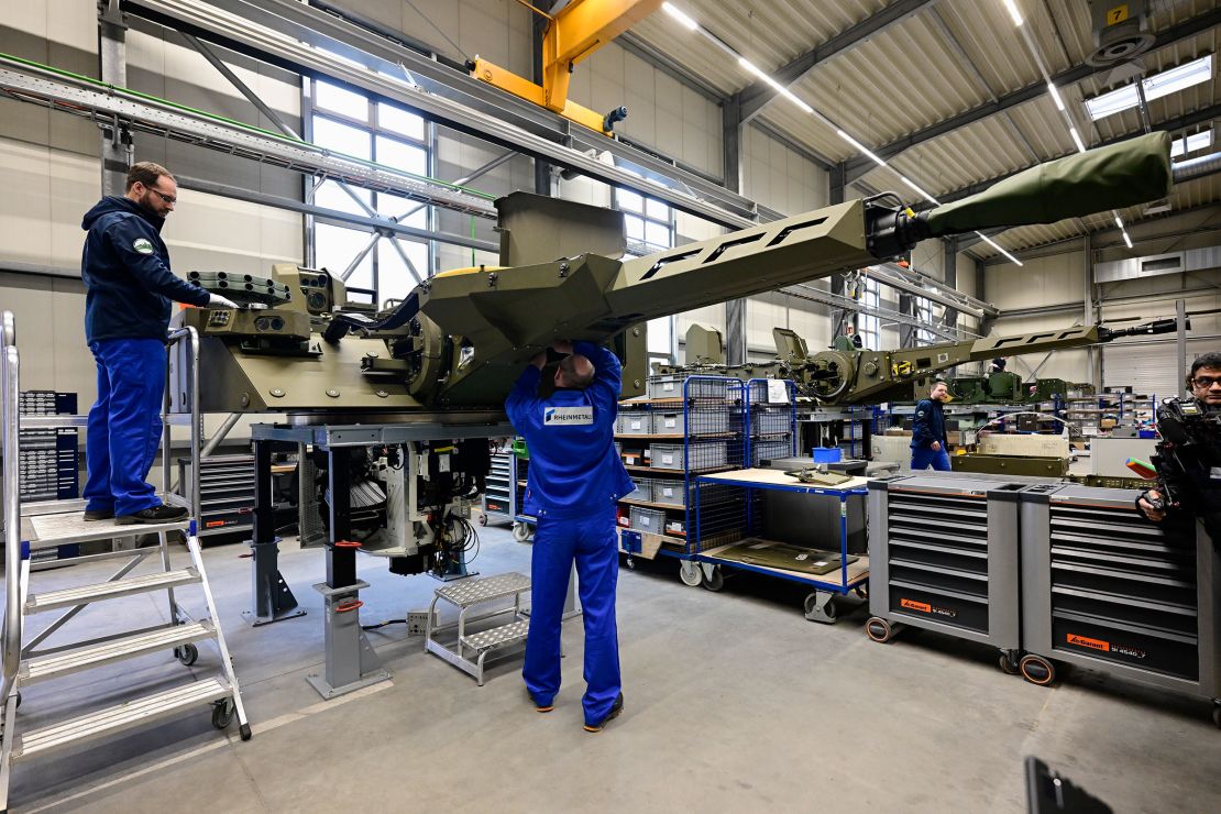 Employees work at a production line as German Chancellor Olaf Scholz and Defence Minister Boris Pistorius attend the groundbreaking ceremony for a new munitions factory of German defense contractor Rheinmetall on February 12 in Unterluess, Germany.