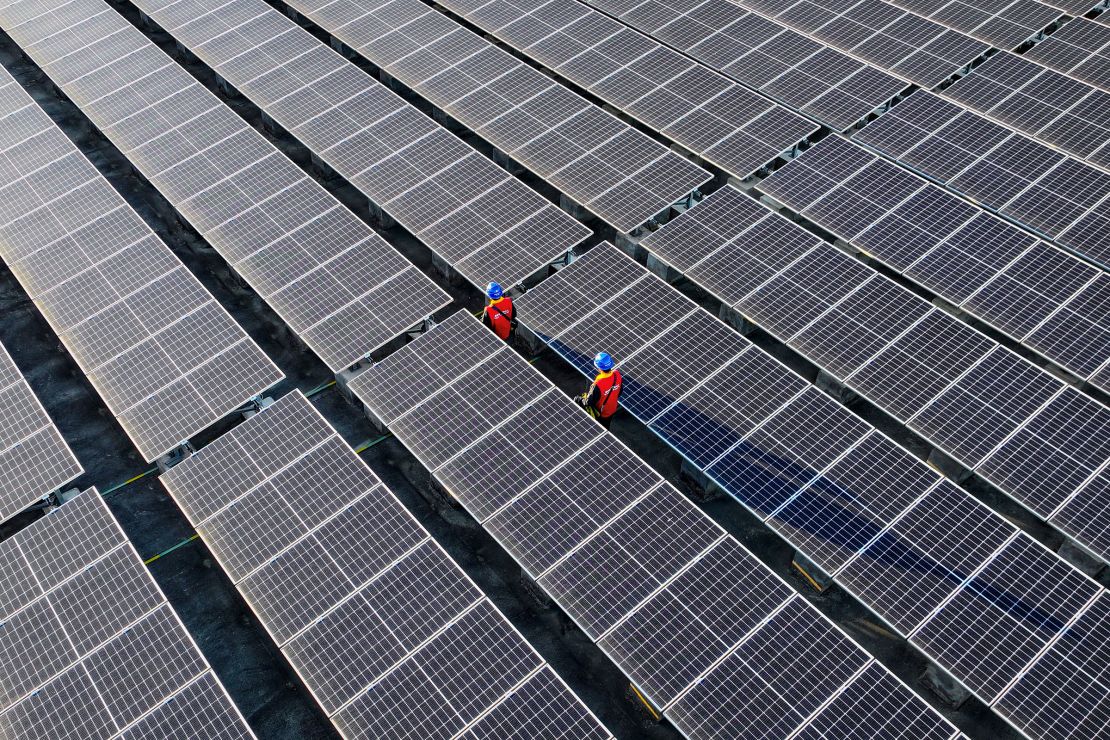 Workers inspect solar panels at a rooftop of a power plant in Fuzhou, in southern China's Fujian province in February. 