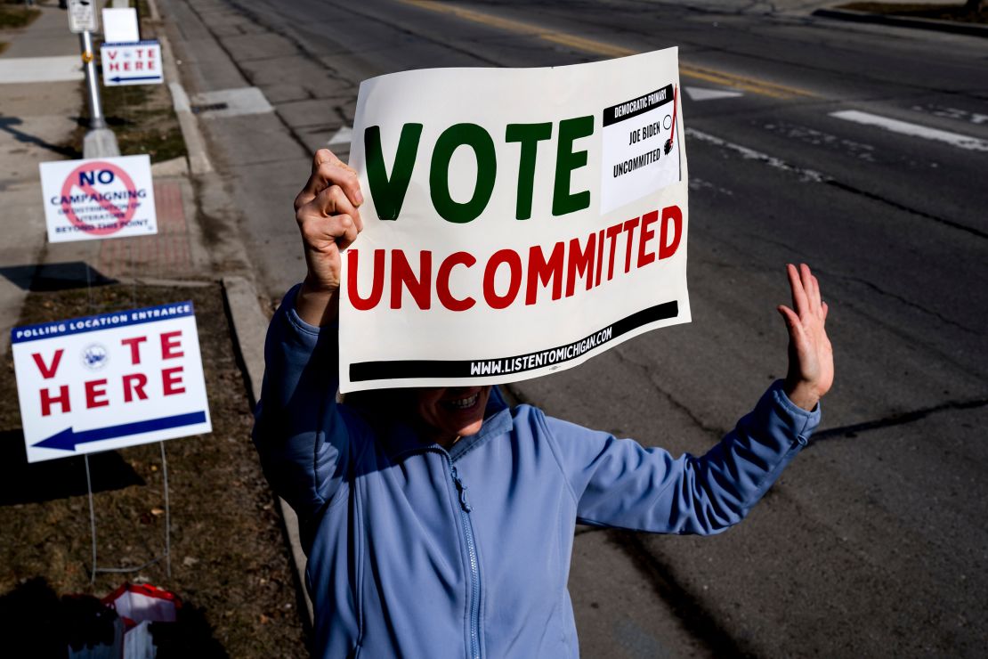 A volunteer holds a "Vote Uncommitted" sign outside of a polling station at Oakman School in Dearborn, Michigan, on Tuesday, February 27. 